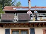Ortsbürgermeister Michael Zimmermann und Elektromeister Daniel Meyerer vor einem neu installierten Balkonkraftwerk der Familie Merz in Hauenstein