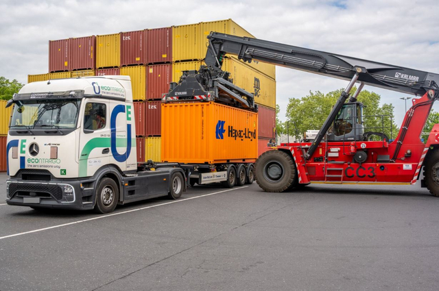 Ein E-Lkw wird im Hafen mit einem Container beladen