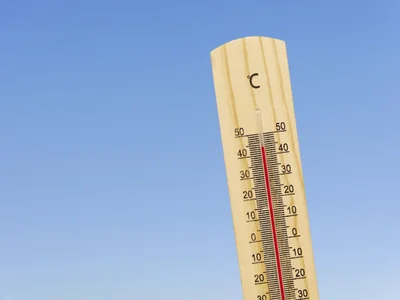 Ein Thermometer ist zu sehen, die Temperatur zeigt über 40 Grad an. Im Hintergrund ist  der Himmel zu sehen.