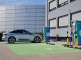 Das Foto zeigt ein Auto an einer Ladesäule vor einem Bürogebäude
