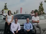 Team der Lotsenstelle vor E-Auto und Ladesäule