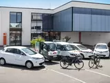 Foto mit E-Fahrzeugen vor einem Firmengebäude