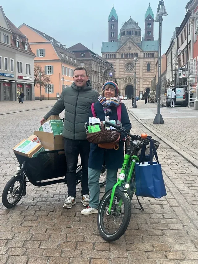 Zwei Menschen mit Lastenfahrrädern, die mit Kisten beladen sind
