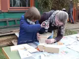Kind und Mutter bauen einen Nistkasten
