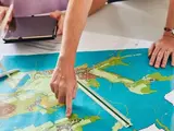 eine Hand zeigt auf eine Karte