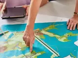 Menschen zeigen auf eine Karte mit Plänen
