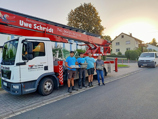 vier Menschen stehen vor einem Kran