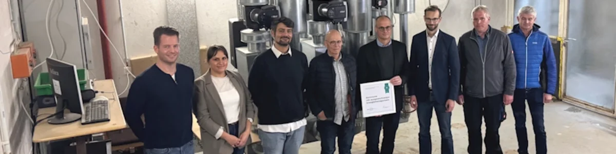 Verschiedene, am Projekt beteiligte Menschen, stehen im Heizungskeller der Heinrich-Roth-Schule.