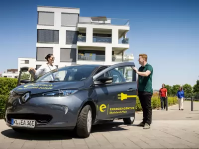 Mann steht neben E-Auto