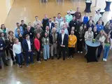 Viele Leute stehen beisammen und schauen in die Kamera
