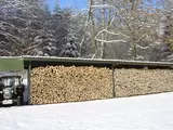 Gelagertes Holz mit Traktor im Schuppen