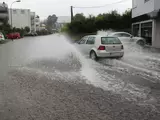 Überschwemmte Straße, durch die ein Auto fährt