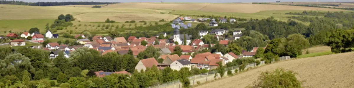 Blick auf eine Kommune mit umgebender Landschaft