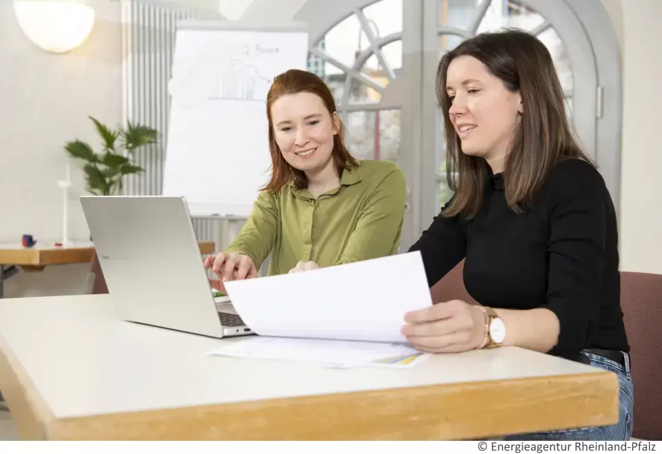 Zwei Mitarbeiterinnen besprechen sich am Laptop
