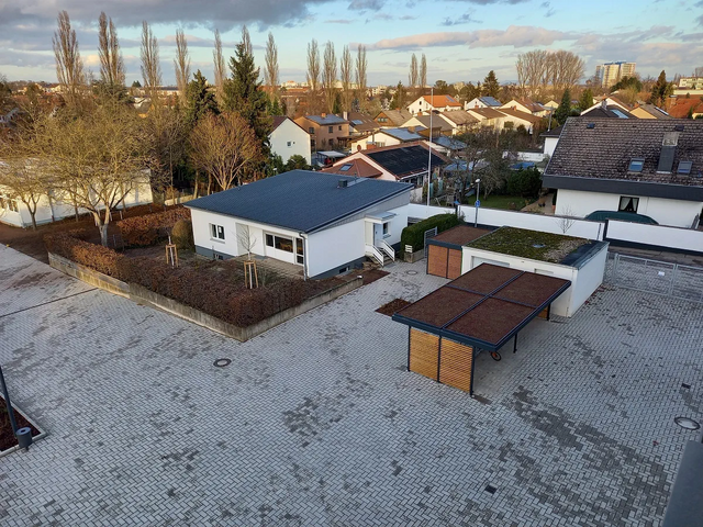 Blick von oben auf einen Schulhof mit begrüntem Dach über Mülleimern