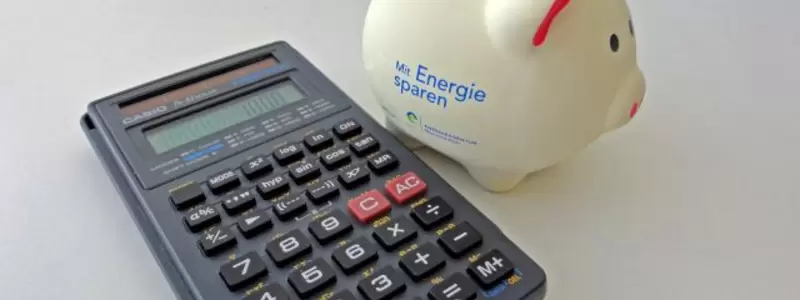 Auf einem Tisch liegen ein Taschenrechner und ein Sparschwein