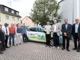 Carsharing Auto EGOMobil umringt von Menschen