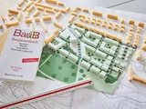 Das Modell einer Stadt liegt auf dem Tisch, daneben das Baugesetzbuch