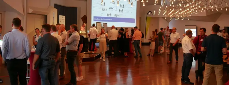 Viele Personen stehen in Gruppen in einem Raum und unterhalten sich