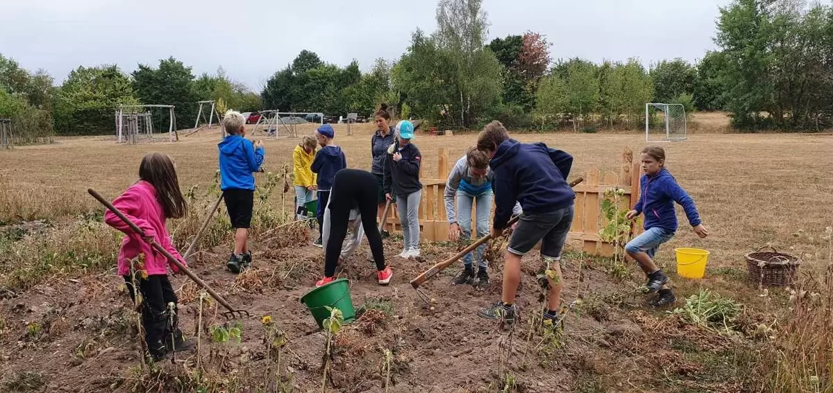 Kinder bearbeiten ein Feld in Bleckhausen