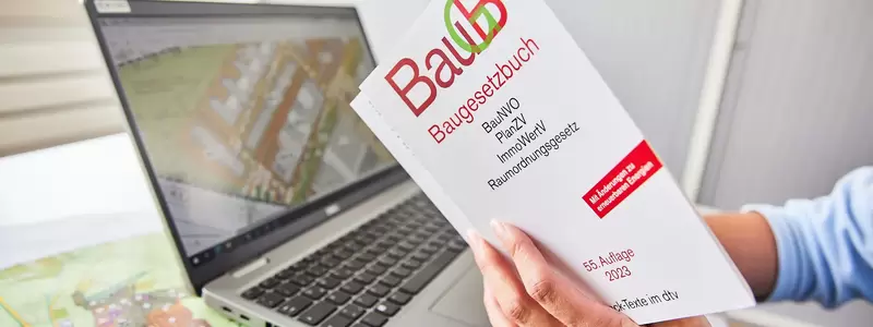 Laptop mit Lageplan und Baugesetzbuch