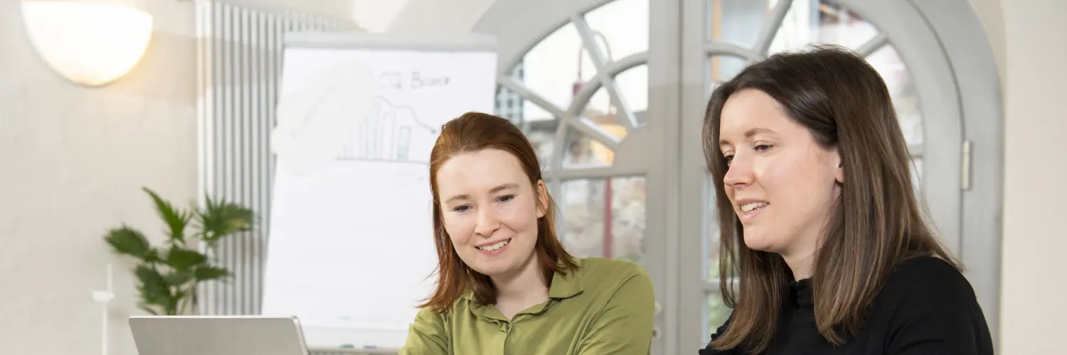 Zwei Frauen schauen gemeinsam in den PC